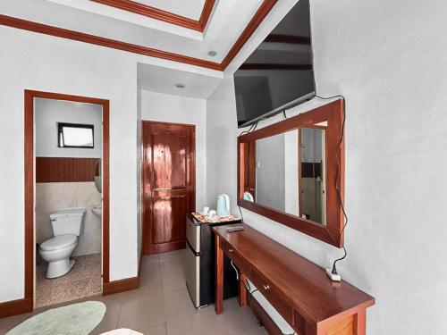 a bathroom with a sink and a mirror and a toilet at Caliah Homes Apartelle in Balamban