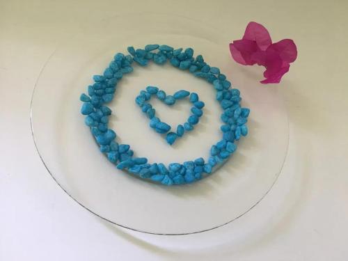 a heart shaped cake with blue beads on a plate at Spacious Apartment in Mahébourg with Sea View in Mahébourg