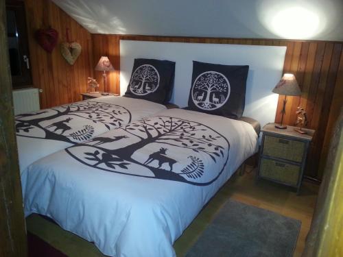 a bedroom with a bed with black and white pillows at Chalet in Hommert near Sarrebourg in Hommert