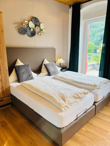 two twin beds in a room with a window at Mosel-Landhaus Hotel Oster in Ediger-Eller