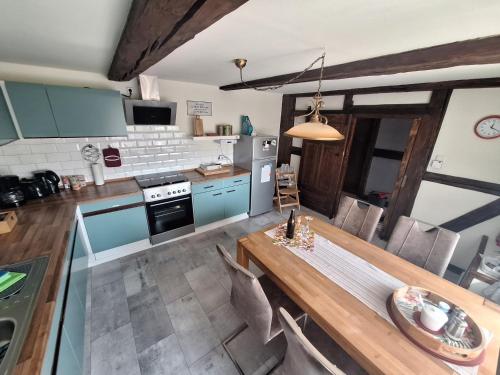 a kitchen with a wooden table and blue cabinets at FeWo Am alten Holzplatz in Drübeck