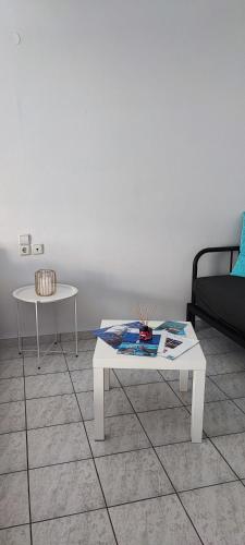 a living room with a white table and a couch at Casa Blu Loft in Néa Ankhíalos