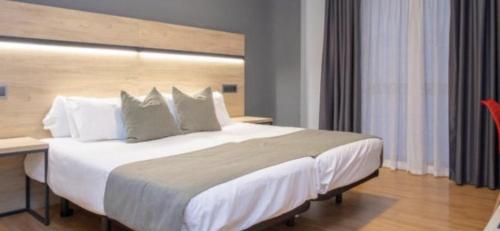 a large white bed in a hotel room at VTZ Hotel El Príncipe in Zaragoza