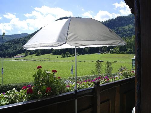 a white umbrella on a balcony with flowers at Apartment am Wolfgangsee in Strobl