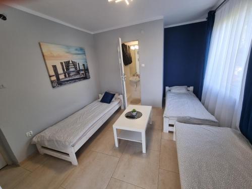 a small room with two beds and a table at Pokoje Złota Rybka in Stegna