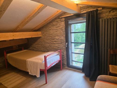 Un dormitorio con una cama y una ventana grande. en Muranche Lofts N, en Valtournenche