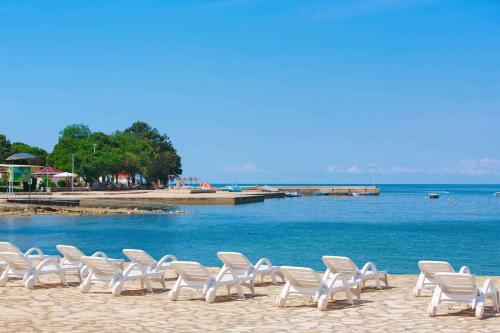 a row of chairs on a beach next to the water at Apartments in Fiorini - Istrien 11997 in Fiorini