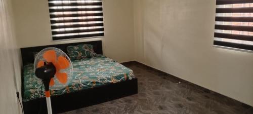 Sango OttaにあるOgunyemi's Villa - Ijàkòのファン付きのベッドが備わる客室です。