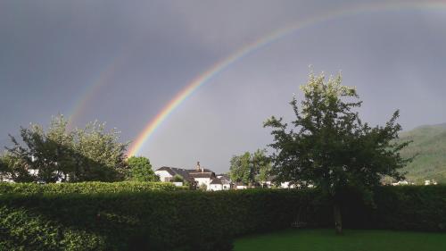 a rainbow is in the sky over a hedge at Apartment am Wolfgangsee in Strobl