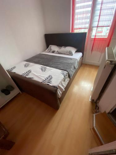 シャバツにあるŠabac Apartmaniのウッドフロアのドミトリールーム(ベッド1台)