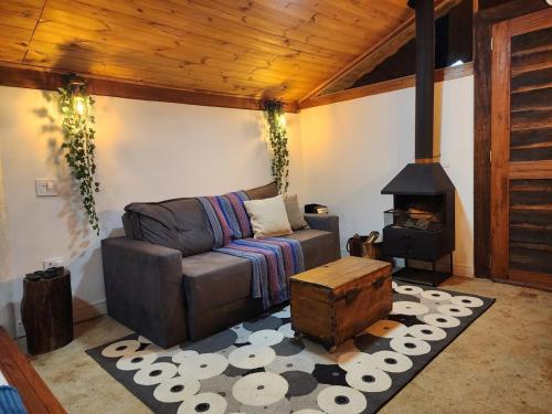 a living room with a couch and a wood stove at Na Serra Chalés in Itapecerica da Serra