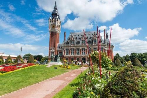 a large building with a clock tower on top of it at Ambiance Bohème, Confort Cosy in Calais