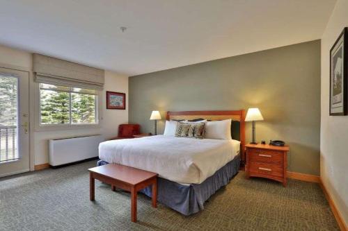 una camera da letto con un letto e un tavolo in una stanza di Killington Grand Resort Hotel a Killington