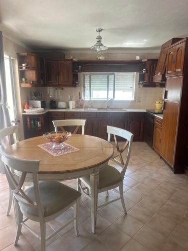 a kitchen with a wooden table and chairs in it at Maison de village 3 CHAMBRES in Souto Sico