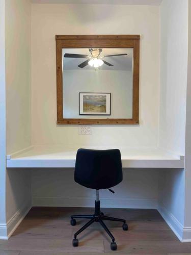 a mirror and a black chair in a room at Comfy King Beds and Fast Wi-Fi near KC stadiums in Independence