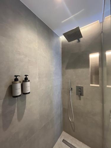 a bathroom with two soap dispensers on the wall at Mina Luxury Rooms in Tirana