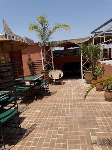 a patio with tables and chairs and palm trees at Riad Dihya in Marrakech