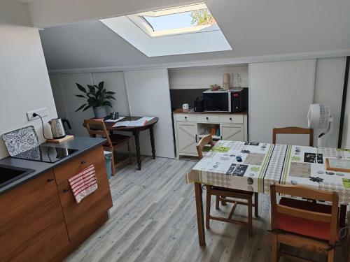 a living room with a kitchen with a table and a counter at Calme, proche Bordeaux - jardin et chats in Bassens