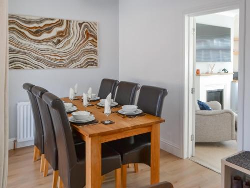 a dining room with a wooden table and black chairs at Beaumont in Morpeth
