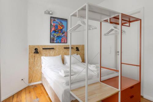 una camera da letto con un letto bianco con una parete in vetro di Mooeve Boxi Studios a Berlino