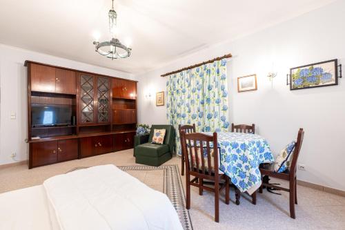 a living room with a dining table and a tv at Apartamento Hortênsia in Furnas
