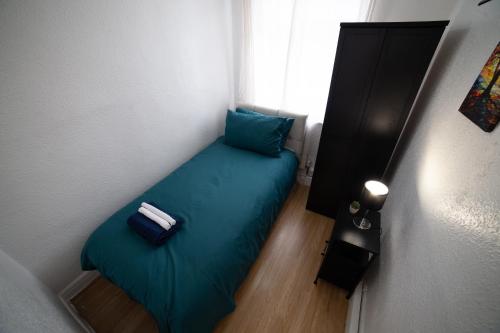 a small bedroom with a blue bed in a room at 3 Bed Pet Friendly Home, With BBQ in Dartford
