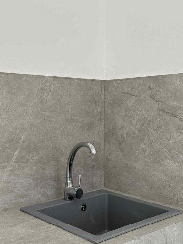 a kitchen sink with a faucet on a wall at Cycladic View III in Ios Chora