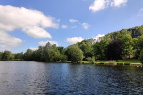 a view of a lake with trees and clouds at Ferienhaus Waldblick, 55 qm, 1 Schlafzimmer in Bad Wünnenberg
