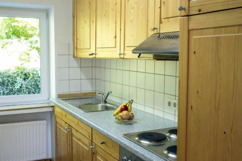 a kitchen with a sink and a bowl of fruit at Ferienhaus Waldblick, 130 qm, 3 Schlafzimmer in Bad Wünnenberg