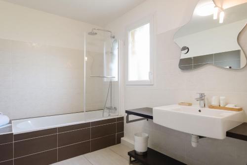 a bathroom with a sink and a bath tub and a sink at Le Mas du Lingousto in Cuers