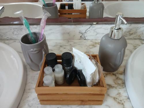 a wooden box with toothbrushes and other items on a bathroom counter at La casa di ale in Latina