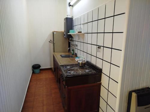a small kitchen with a stove and a sink at Tercer Ojo Apart Hotel in Capilla del Monte