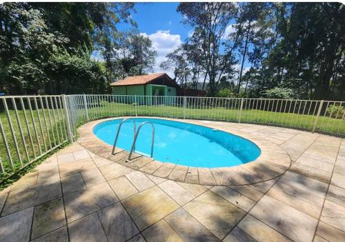 a swimming pool with a fence around it at Na Serra Chalés in Itapecerica da Serra