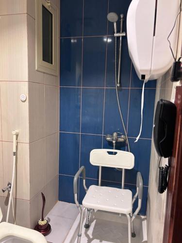 a bathroom with a toilet and a chair in it at فندق هيلا آن للايواء السياحي Hailaann Hotel in Quai