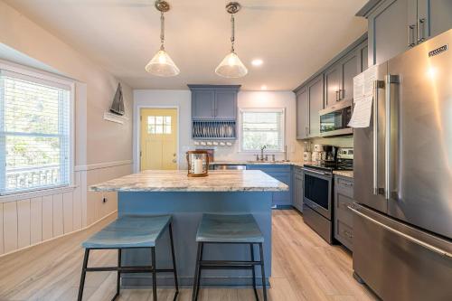 a kitchen with a large blue island with two stools at D4414 Exhibit Sea. Soundfront, Stunning Sunsets, Pier, Private Pool & Hot Tub! in Sanderling