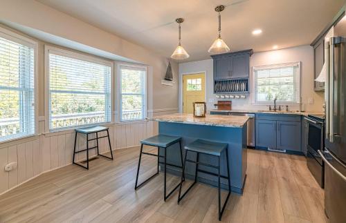 a kitchen with blue cabinets and a blue island with stools at D4414 Exhibit Sea. Soundfront, Stunning Sunsets, Pier, Private Pool & Hot Tub! in Sanderling