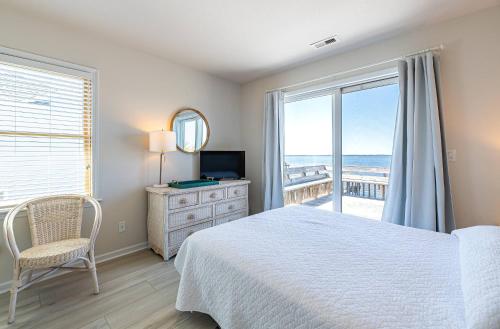 a bedroom with a bed and a view of the ocean at D4414 Exhibit Sea. Soundfront, Stunning Sunsets, Pier, Private Pool & Hot Tub! in Sanderling