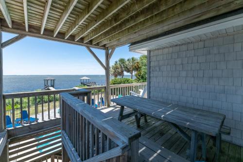 a wooden deck with a bench and the ocean at D4414 Exhibit Sea. Soundfront, Stunning Sunsets, Pier, Private Pool & Hot Tub! in Sanderling