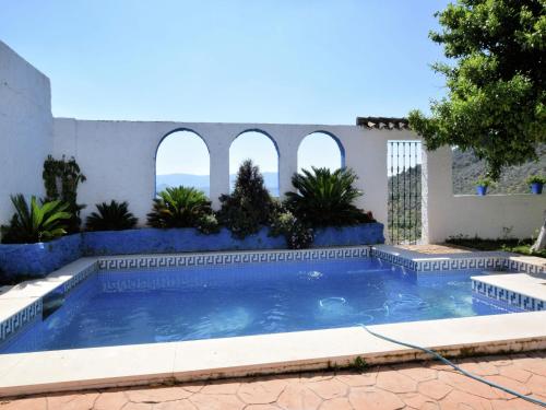 a swimming pool in a yard with three arches at Holiday Home in Zagrilla Alta with Pool in Zagrilla