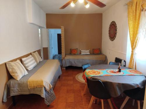 a room with two beds and a table in it at Tercer Ojo Apart Hotel in Capilla del Monte