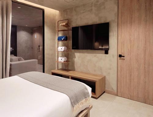 a bedroom with a bed and a television in it at Kuuna Luxury Stays by Wynwood House in Medellín