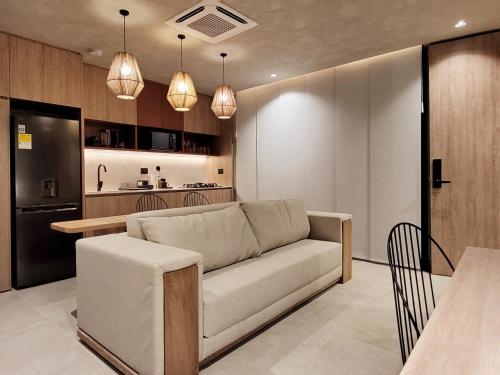 a living room with a couch and a kitchen at Kuuna Luxury Stays by Wynwood House in Medellín