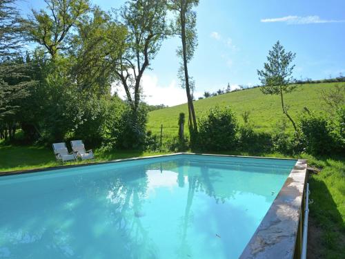 a swimming pool in a yard with a hill in the background at Sunny Watermill with Heated Pool in Brandonnet