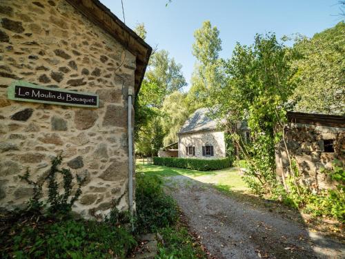 a stone building with a sign on the side of it at Sunny Watermill with Heated Pool in Brandonnet