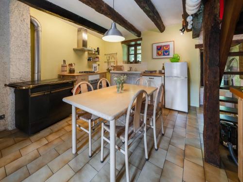 a kitchen with a table and chairs and a refrigerator at Sunny Watermill with Heated Pool in Brandonnet