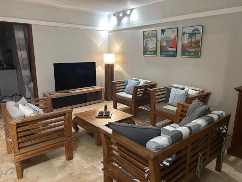a living room with couches and a flat screen tv at Villa Rea at Tamarin Beach in Tamarin