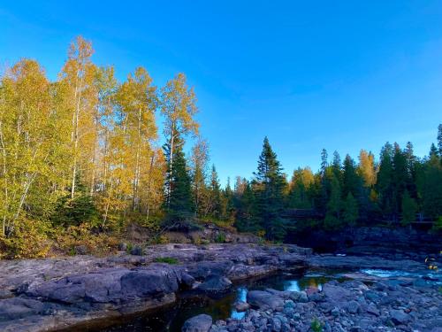 a river with rocks and trees in the background at Gooseberry Trailside Suites by Heirloom Boutique Collection in Two Harbors