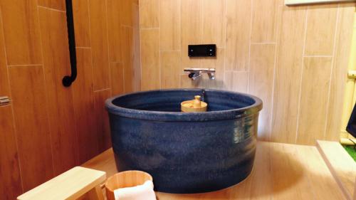 a bathroom with a blue tub with a candle in it at Japanese Bath House 5min to Namba Free Parking101 in Osaka