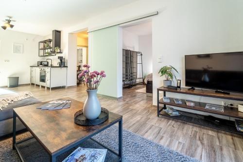 a living room with a vase of flowers on a table at Select-Home 2 - Netflix - Kaffee&Tee - Parkplatz - viele Extras in Bruck in der Oberpfalz