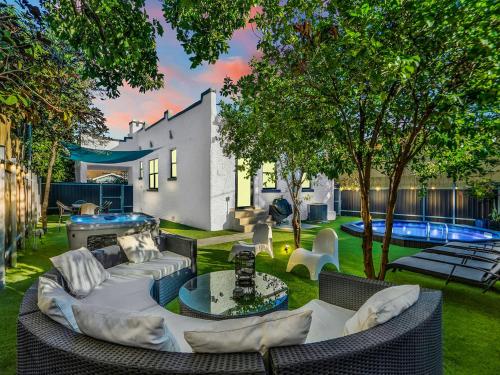 an outdoor patio with a couch and chairs and a pool at Villa Tranquillo Calle Ocho Pool & Hot Tub in Miami